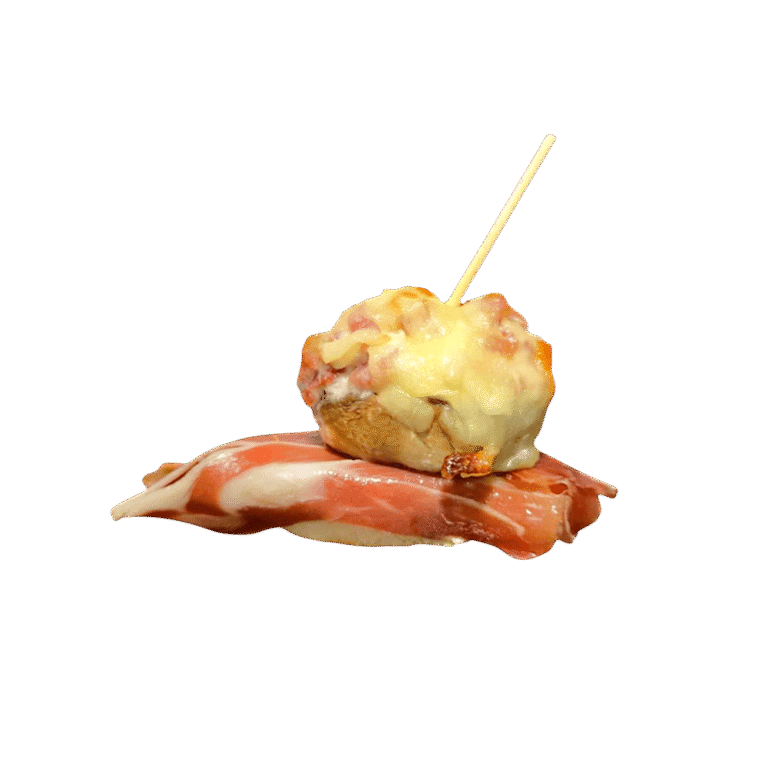 Champiñon gratinado relleno con muselina de jamón ibérico y reposado en una loncha de jamón ibérico