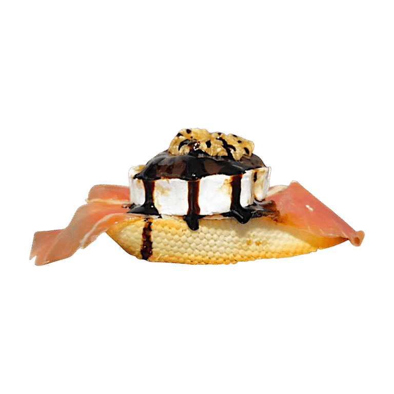 Pincho de queso de cabra con cebolla caramelizada, nueces y reposada en una loncha de jamón ibérico